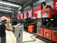 Workers are operating a machine to cast a sleeper at the Nanchang-Jiujiang Intercity Railway's Yongrepair sleeper yard in Jiujiang, China, o...