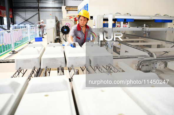 Workers are installing fasteners for a sleeper at the Nanchang-Jiujiang Intercity Railway's Yongrepair sleeper yard in Jiujiang, Jiangxi pro...