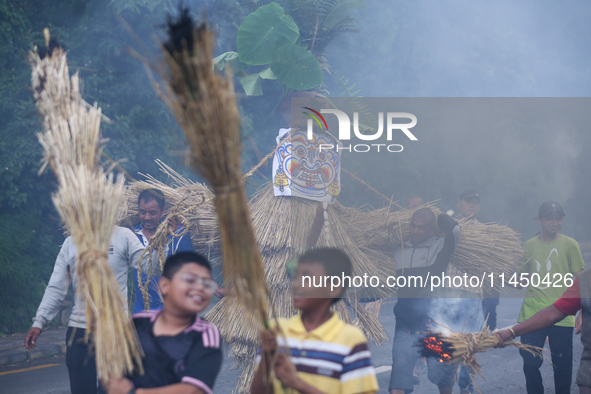 Children are carrying live hay straw as they are taking part in the immolation ceremony of demon deity Ghantakarna to veer off bad omens and...