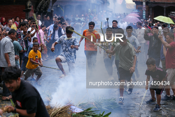 People are dragging the effigy of the demon deity Ghantakarna after setting it on fire to veer off bad omens and ward off evil spirits in Bh...