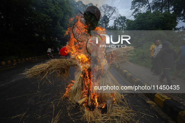 People are setting the effigy of the demon deity Ghantakarna on fire after dragging it down to a crossroad in Bhaktapur, Nepal, on August 2,...