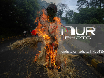 People are setting the effigy of the demon deity Ghantakarna on fire after dragging it down to a crossroad in Bhaktapur, Nepal, on August 2,...