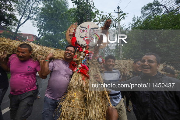 People are dragging the effigy of the demon deity Ghantakarna to set it on fire to veer off bad omens and ward off evil spirits in Bhaktapur...