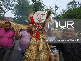 People are dragging the effigy of the demon deity Ghantakarna to set it on fire to veer off bad omens and ward off evil spirits in Bhaktapur...