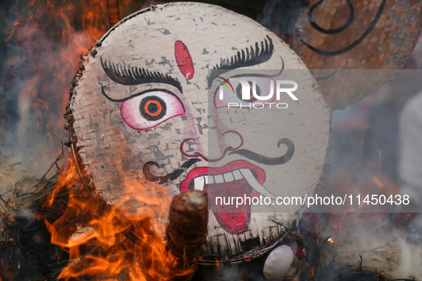 People are setting the effigy of the demon deity Ghantakarna on fire after dragging it down to a crossroad in Bhaktapur, Nepal, on August 2,...