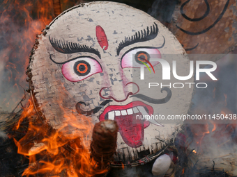 People are setting the effigy of the demon deity Ghantakarna on fire after dragging it down to a crossroad in Bhaktapur, Nepal, on August 2,...