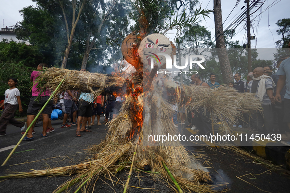 People are setting the effigy of the demon deity Ghantakarna on fire after dragging it down to a crossroad in Bhaktapur, Nepal, on August 2,...