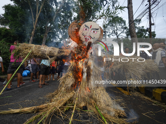 People are setting the effigy of the demon deity Ghantakarna on fire after dragging it down to a crossroad in Bhaktapur, Nepal, on August 2,...