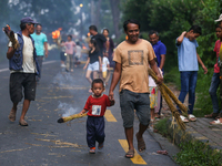 A child is carrying a live hay straw as he walks along with his father during the immolation ceremony of demon deity Ghantakarna to veer off...