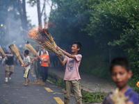 Children are carrying live hay straw as they are taking part in the immolation ceremony of demon deity Ghantakarna to veer off bad omens and...