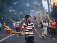 Children are carrying live hay straw as they are taking part in the immolation ceremony of demon deity Ghantakarna to veer off bad omens and...