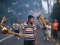 Children are carrying live hay straw as they are taking part in the immolation ceremony of demon deity Ghantakarna to veer off bad omens and...