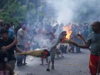 Children are carrying live hay straw as they are taking part in the immolation ceremony of demon deity Ghantakarna to veer off bad omens and...