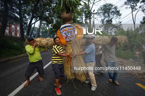 People are dragging the effigy of the demon deity Ghantakarna to set it on fire to veer off bad omens and ward off evil spirits in Bhaktapur...