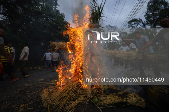 People are setting the effigy of the demon deity Ghantakarna on fire after dragging it down to a crossroad in Bhaktapur, Nepal, on August 2,...