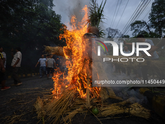 People are setting the effigy of the demon deity Ghantakarna on fire after dragging it down to a crossroad in Bhaktapur, Nepal, on August 2,...