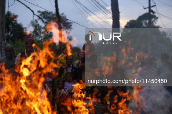 People are setting the effigy of the demon deity Ghantakarna on fire after dragging it down to a crossroad in Bhaktapur, Nepal, on August 2,...