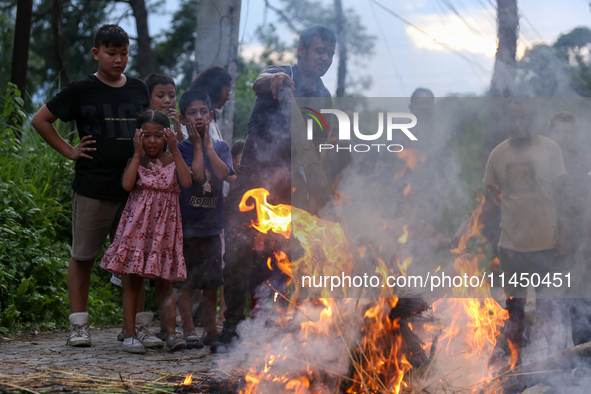 People are setting the effigy of the demon deity Ghantakarna on fire after dragging it down to a crossroad in Bhaktapur, Nepal, on August 2,...