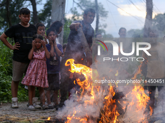 People are setting the effigy of the demon deity Ghantakarna on fire after dragging it down to a crossroad in Bhaktapur, Nepal, on August 2,...