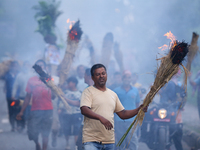 A man is carrying live hay straw as he takes part in the immolation ceremony of demon deity Ghantakarna to veer off bad omens and ward off e...