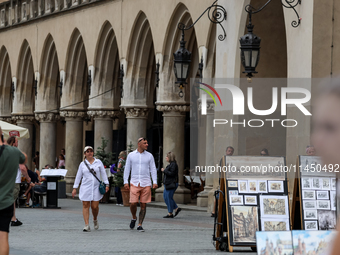 Visitors walk along stalls with hand made local souvenirs during a festival of UNESCO enlisted site of historical trade centre in Krakow, Po...