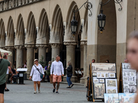 Visitors walk along stalls with hand made local souvenirs during a festival of UNESCO enlisted site of historical trade centre in Krakow, Po...