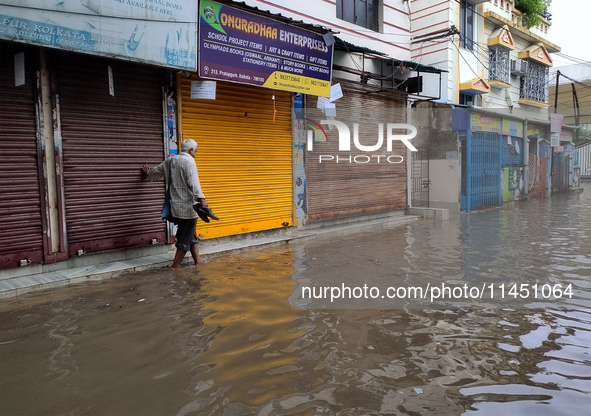 A person is walking on a water-logged street in Kolkata, India, on August 3, 2024. 