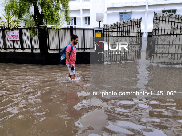 A person is walking on a water-logged street in Kolkata, India, on August 3, 2024. 