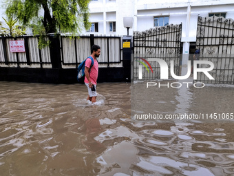 A person is walking on a water-logged street in Kolkata, India, on August 3, 2024. (