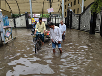 People are walking on a waterlogged street after heavy rains in Kolkata, India, on August 3, 2024. (