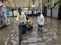 People are walking on a waterlogged street after heavy rains in Kolkata, India, on August 3, 2024. (