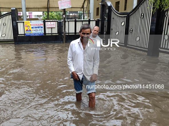 A person is walking on a water-logged street in Kolkata, India, on August 3, 2024. 