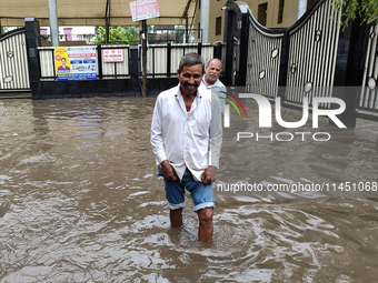 A person is walking on a water-logged street in Kolkata, India, on August 3, 2024. (