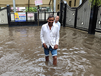 A person is walking on a water-logged street in Kolkata, India, on August 3, 2024. (