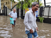 People are walking on a waterlogged street after heavy rains in Kolkata, India, on August 3, 2024. (