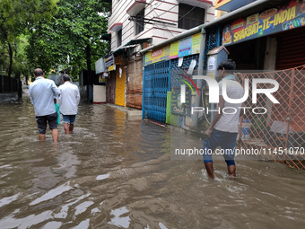 People are walking on a waterlogged street after heavy rains in Kolkata, India, on August 3, 2024. (