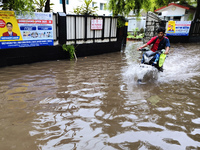 A man is riding a bike in a waterlogged street after heavy rains in Kolkata, India, on August 3, 2024. (