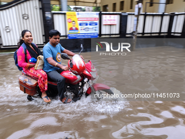 A man is riding a bike in a waterlogged street after heavy rains in Kolkata, India, on August 3, 2024. 