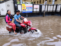 A man is riding a bike in a waterlogged street after heavy rains in Kolkata, India, on August 3, 2024. (