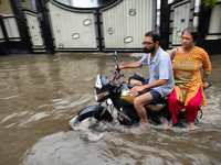 A man is riding a bike in a waterlogged street after heavy rains in Kolkata, India, on August 3, 2024. (