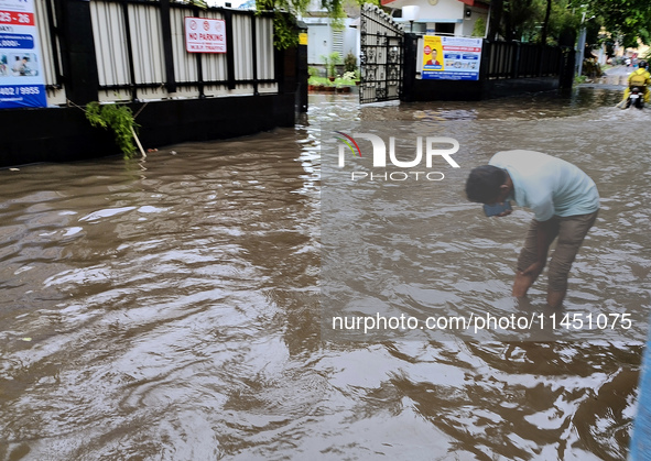 A person is walking on a water-logged street in Kolkata, India, on August 3, 2024. 