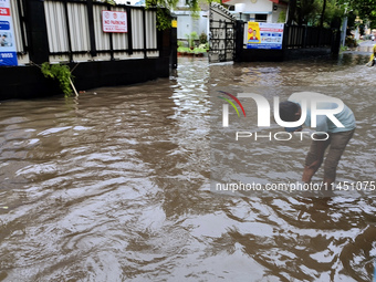 A person is walking on a water-logged street in Kolkata, India, on August 3, 2024. (