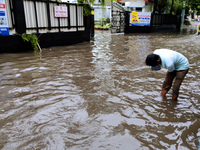 A person is walking on a water-logged street in Kolkata, India, on August 3, 2024. (