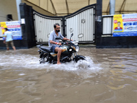 A man is riding a bike in a waterlogged street after heavy rains in Kolkata, India, on August 3, 2024. (