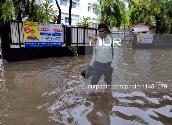 A person is walking on a water-logged street in Kolkata, India, on August 3, 2024. 