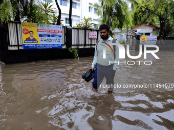 A person is walking on a water-logged street in Kolkata, India, on August 3, 2024. (