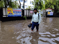 A person is walking on a water-logged street in Kolkata, India, on August 3, 2024. (