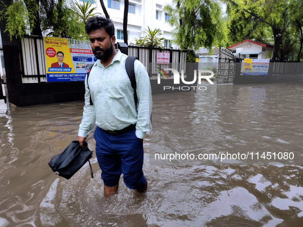 A person is walking on a water-logged street in Kolkata, India, on August 3, 2024. 