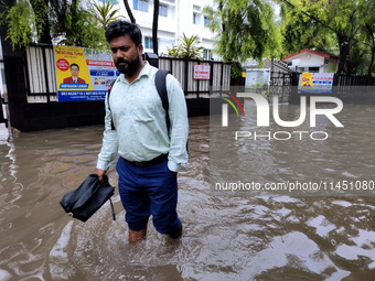 A person is walking on a water-logged street in Kolkata, India, on August 3, 2024. (