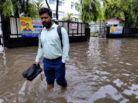 A person is walking on a water-logged street in Kolkata, India, on August 3, 2024. (